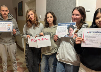 Grupa wychowanków bursy szkolnej prezentuje plakaty informacyjne dotyczące depresji oraz hasło „Stop depresji”. Na kolejnych zdjęciach jedna z uczestniczek przypina materiały edukacyjne na tablicy informacyjnej na korytarzu bursy. Plansze zawierają informacje o objawach depresji, sposobach szukania pomocy oraz profilaktyce.