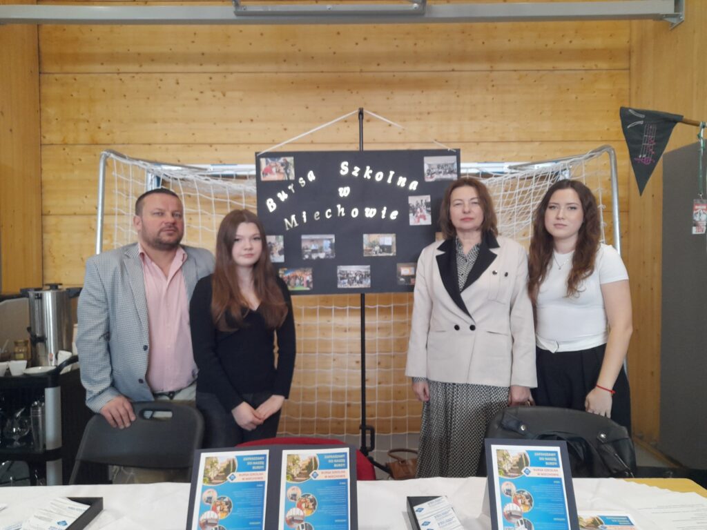 Stoisko Bursy Szkolnej w Miechowie podczas Powiatowych Targów Edukacji – przedstawiciele bursy udzielają informacji odwiedzającym, prezentują materiały promocyjne oraz odpowiadają na pytania dotyczące warunków pobytu i oferty placówki