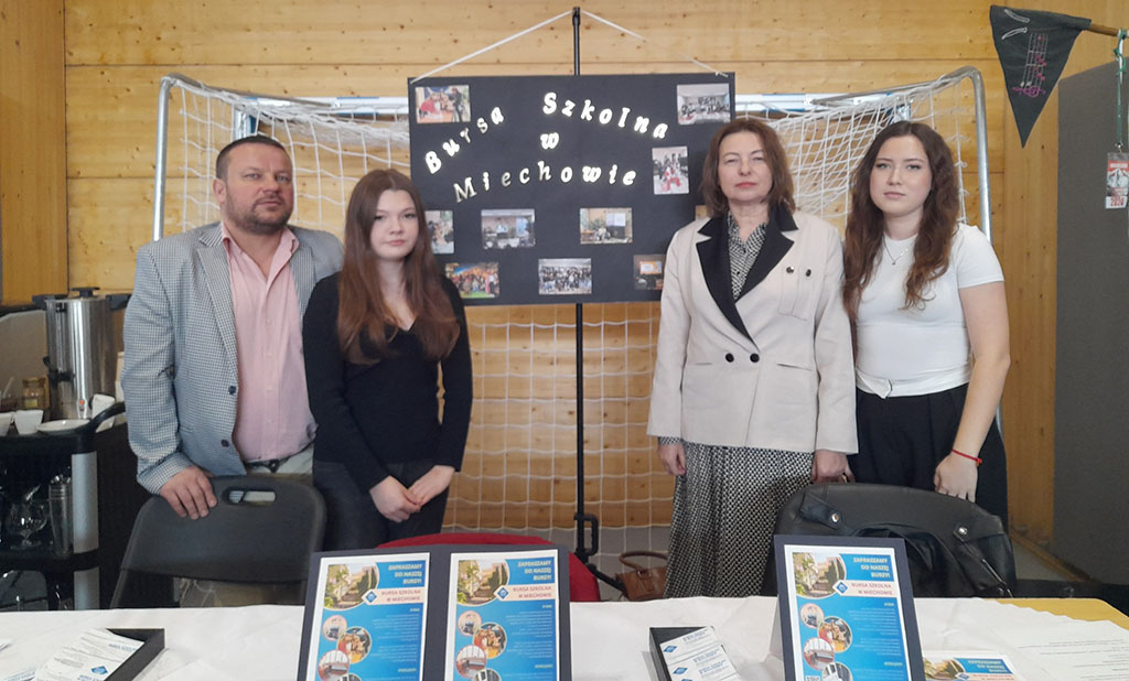 Stoisko Bursy Szkolnej w Miechowie podczas Powiatowych Targów Edukacji – przedstawiciele bursy udzielają informacji odwiedzającym, prezentują materiały promocyjne oraz odpowiadają na pytania dotyczące warunków pobytu i oferty placówki