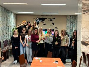 Uczniowie bursy podczas obchodów Dnia Kobiet – chłopcy wręczają dziewczętom tulipany i drobne upominki, wspólne rozmowy przy stołach oraz wieczór filmowy. Na jednym ze zdjęć widoczna jest również gazetka tematyczna poświęcona historii i znaczeniu Dnia Kobiet. Zdjęcia przedstawiają miłą, radosną atmosferę wspólnego świętowania.
