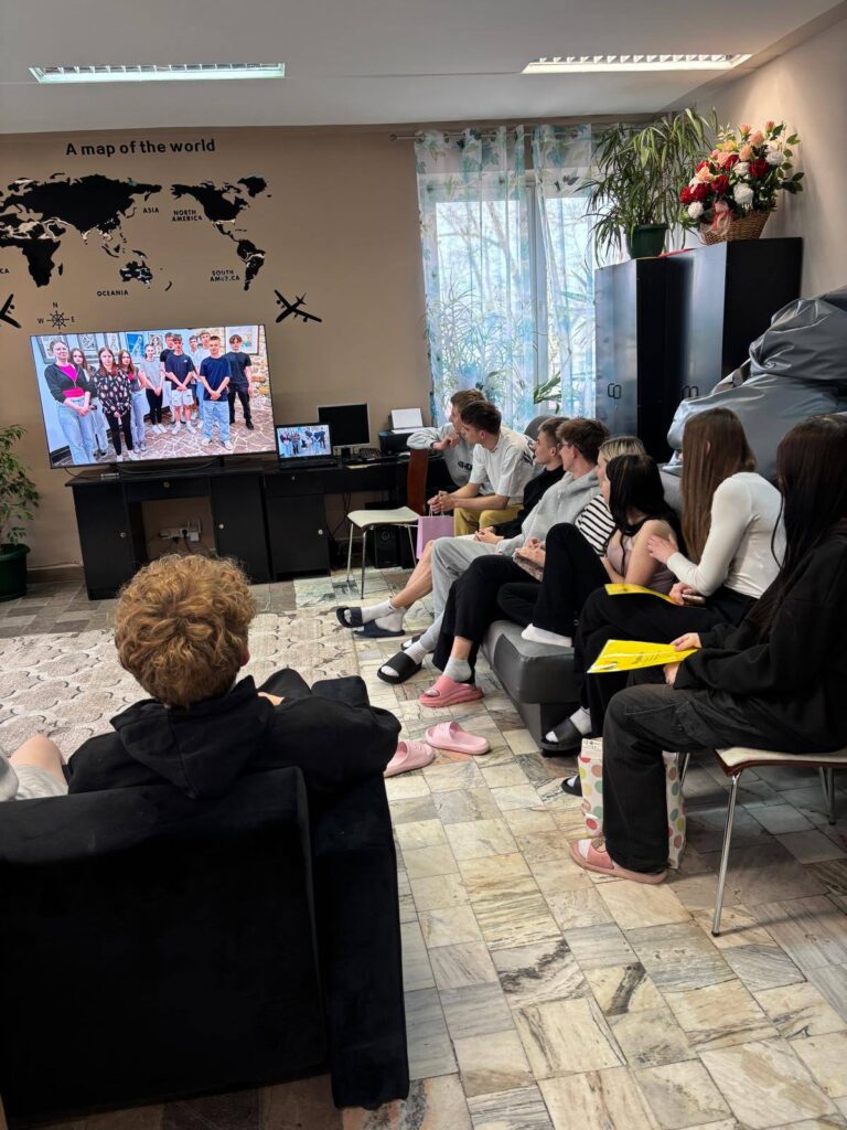 Zdjęcia przedstawiają uroczystość pożegnania maturzystów w Bursie Szkolnej. W sali z ustawionymi stołami i krzesłami grupa młodzieży oraz wychowawcy uczestniczą w oficjalnym spotkaniu. Na jednej z fotografii uczennica trzyma upominek, na innych widoczne jest wręczanie prezentów oraz odczytywanie przemówień i podziękowań. Na stołach znajdują się torby z upominkami. W tle widoczna jest tablica oraz elementy wyposażenia sali. Atmosfera wydarzenia ma charakter uroczysty i podniosły