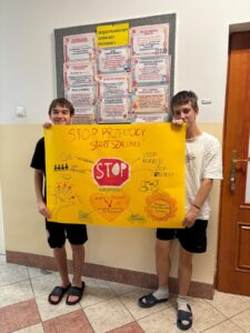 Czworo wychowanków Bursy Szkolnej prezentuje wspólnie przygotowany plakat „Stop przemocy, start szacunku”, promujący przeciwdziałanie przemocy, szacunek i wzajemną pomoc.