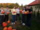 Wychowankowie Bursy Szkolnej w Miechowie podczas warsztatów artystyczno-integracyjnych z okazji Halloween. Zdjęcia przedstawiają zbieranie dyń w gospodarstwie rolnym, tworzenie halloweenowych lampionów, malowanie ozdób gipsowych oraz wspólną pracę i integrację młodzieży podczas zajęć.