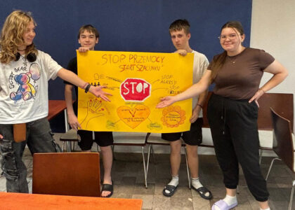 Czworo wychowanków Bursy Szkolnej prezentuje wspólnie przygotowany plakat „Stop przemocy, start szacunku”, promujący przeciwdziałanie przemocy, szacunek i wzajemną pomoc.